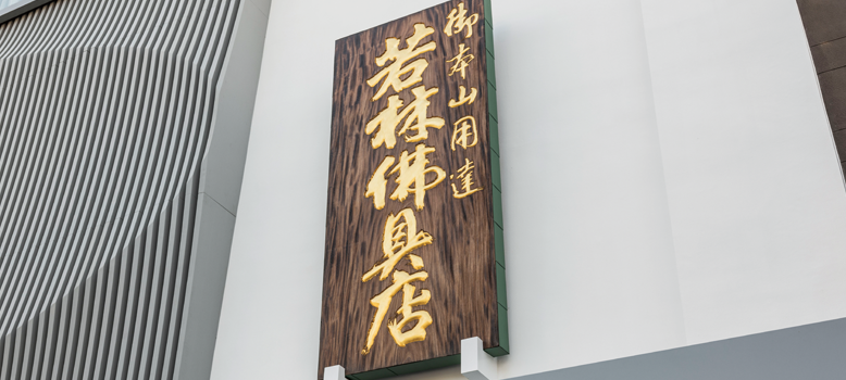 若林佛具製作所の表玄関上にかかる創業から200年の歴史を物語る看板。看板には若林佛具店のほかに、御本山御用達の文字。長年培った伝統工芸の技術と経験、豊富な納入実績をもとに、ご寺院様のお悩みに最適なご提案をします。